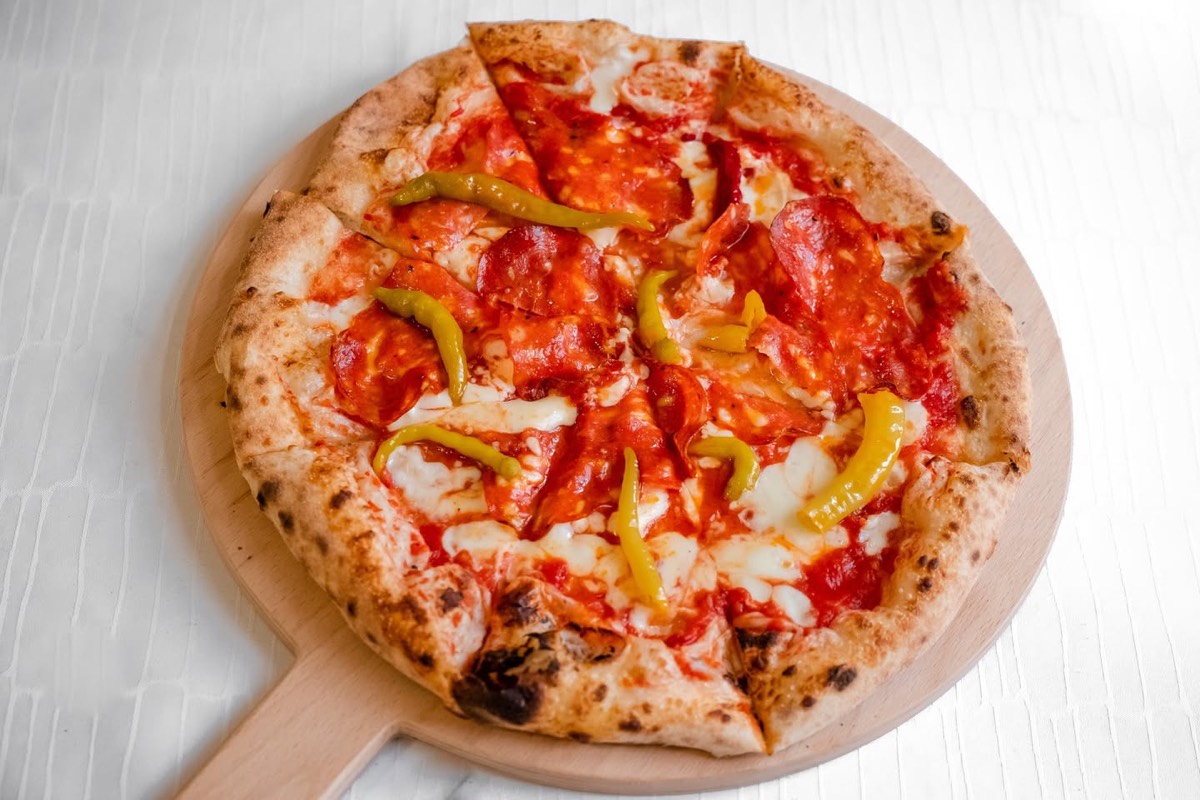 Szalámis pizza fatálcán, csípős paprikával, felülnézetből